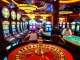Experience the electric atmosphere of 88CLB with engaging players at the roulette wheel and vibrant slot machines.